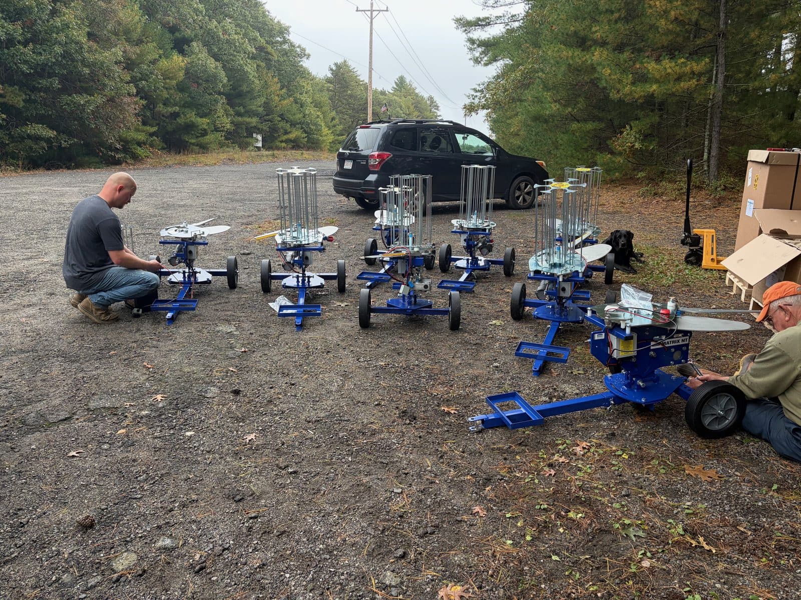 A row of new blue sporting clays throwers being assembled in the parking area