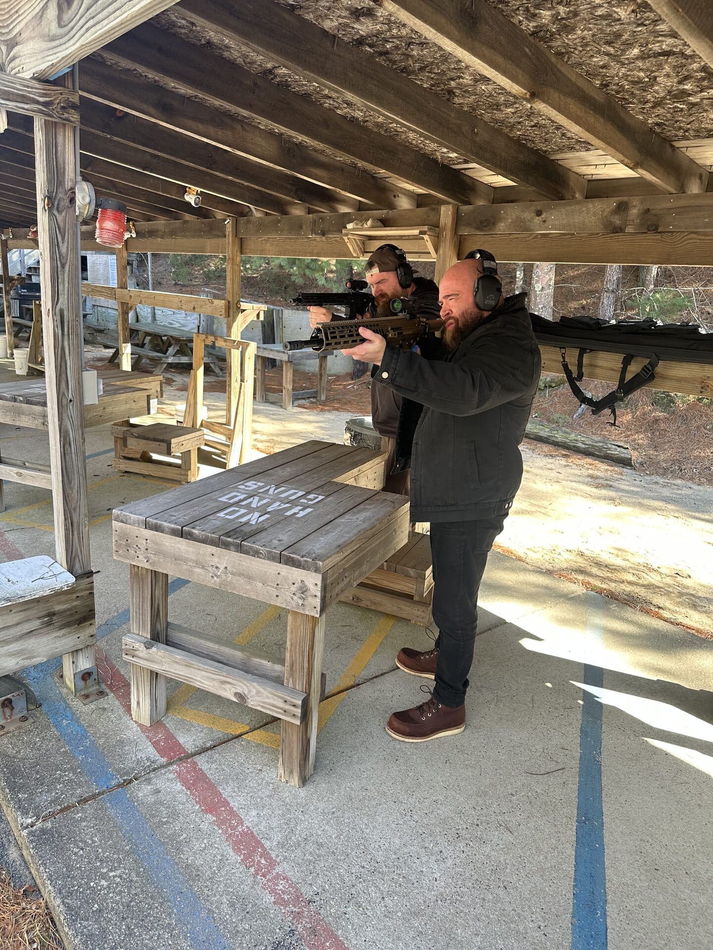 Members shooting rifles at the covered bench