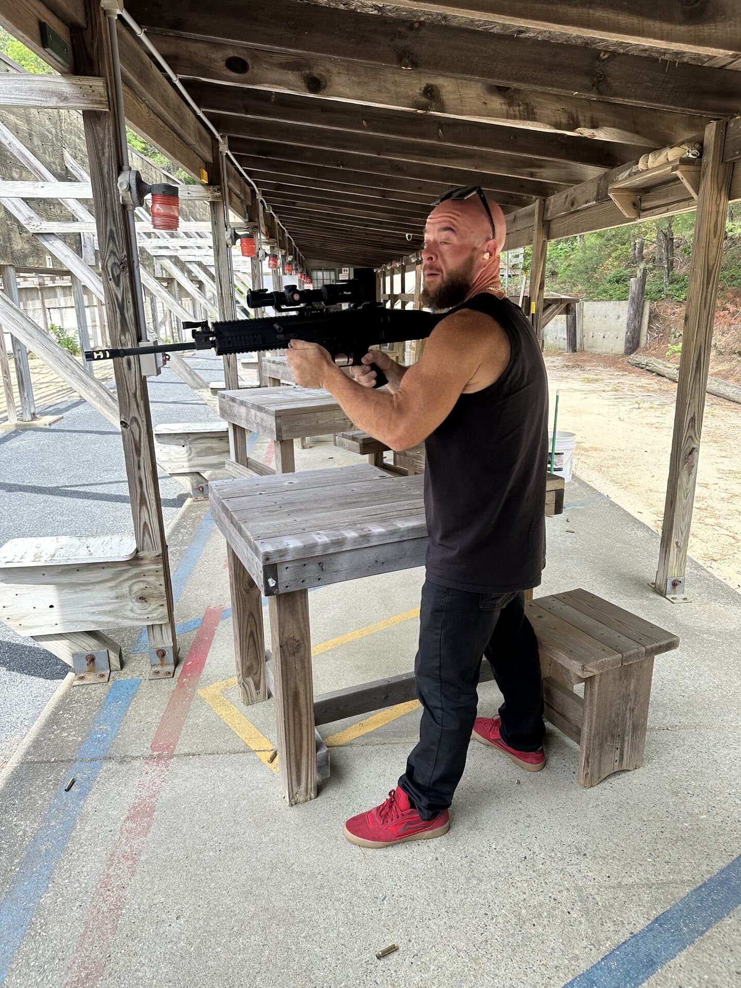 Member at outdoor range with scoped rifle
